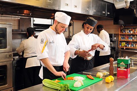 酒店管理专业的学生从专门的餐饮服务讲师那里学习最新的食品准备和餐厅管理技术.